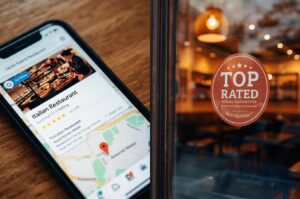 Split screen showing a smartphone displaying a local Italian restaurant listing on a map app next to a top-rated restaurant window decal.