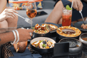 A vibrant table spread of modern fusion dishes and cocktails at a trendy Singapore restaurant, illustrating high-quality food photography that drives customer engagement.