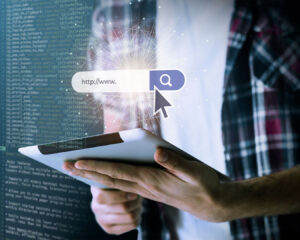 A close-up of a hand holding a tablet with a search bar displayed on the screen, suggesting someone is searching for information online in a clean, modern digital interface.