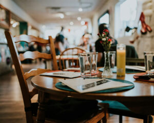 A warm and modern restaurant interior with neatly arranged tables, soft lighting, and a welcoming dining atmosphere.