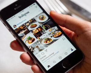 Smartphone displaying the restaurant’s Instagram profile, featuring neatly arranged food posts and a consistent visual style that reflects the brand’s identity