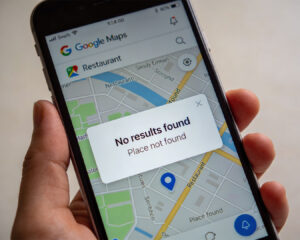 A hand holding a smartphone displaying Google Maps with a “Restaurant not found” message, indicating the business is missing or not properly listed on the map.