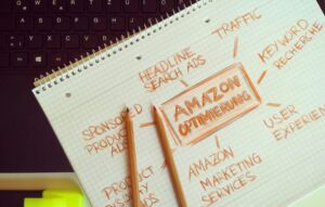 A hand-drawn mind map titled "AMAZON OPTIMIERUNG" sits on a spiral notebook next to a laptop keyboard.