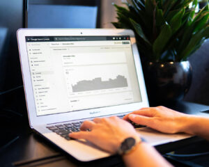 Close-up of a hand using a laptop displaying local SEO strategy data, representing digital marketing planning for small businesses.