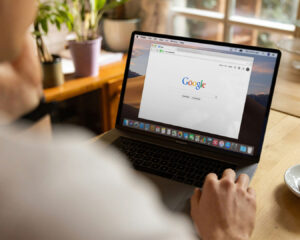A man browsing Google on his laptop, representing online research and information seeking for work