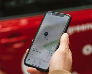 A person holding a smartphone and viewing a digital map with location markers, suggesting they are trying to find a restaurant or business location.