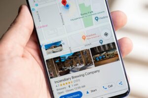 A hand holds a smartphone displaying a Google Maps profile for a brewery called Incendiary Brewing Company.