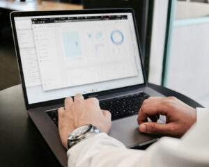 Hands typing on a laptop keyboard, illustrating ongoing optimisation and digital management for a restaurant business.